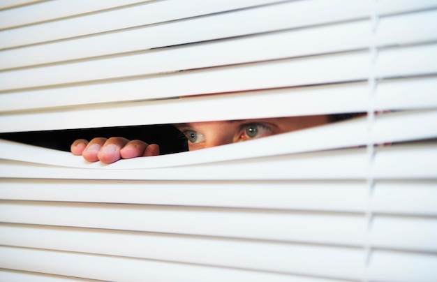 Foto hombre mirando a través de las persianas