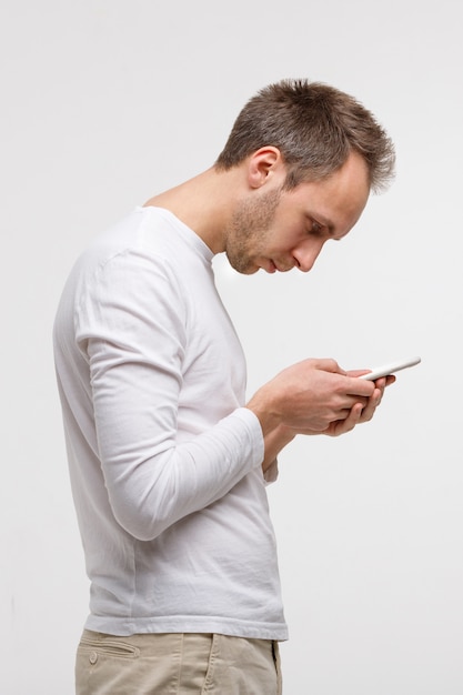 Hombre mirando y usando un teléfono inteligente con escoliosis, postura incorrecta