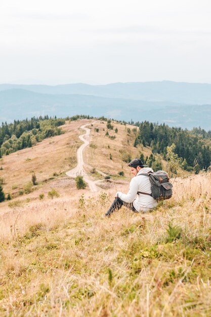 Foto hombre con mochila caminando por las montañas de otoño copiar espacio