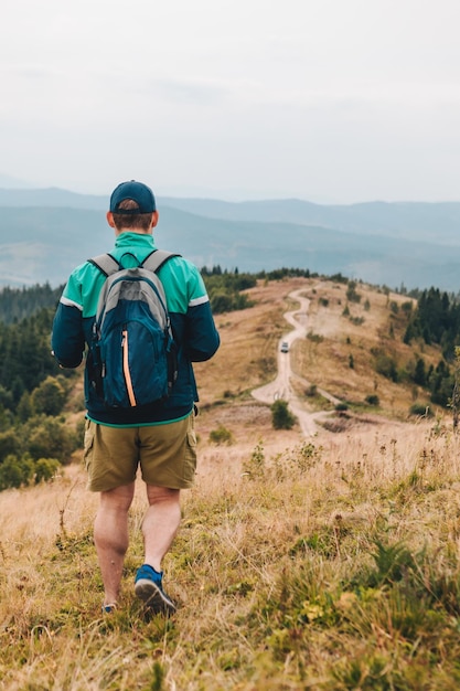 Foto hombre con mochila caminando por las montañas de otoño copiar espacio