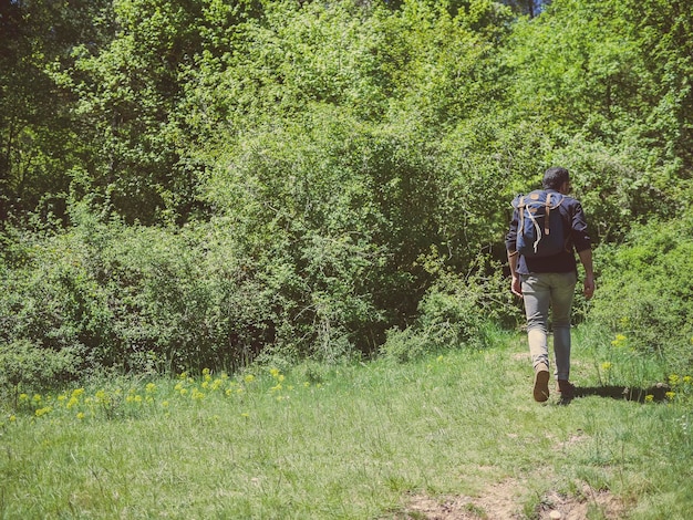 Un hombre con una mochila en una excursión por la naturaleza.