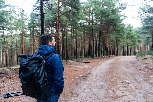 Hombre con mochila explorando un bosque