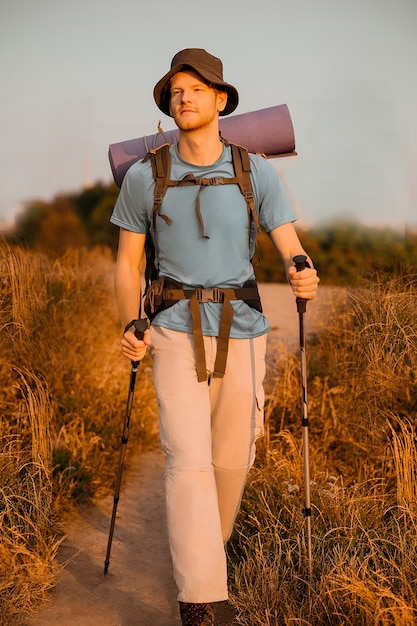 Un hombre con una mochila que se siente bien mientras camina.