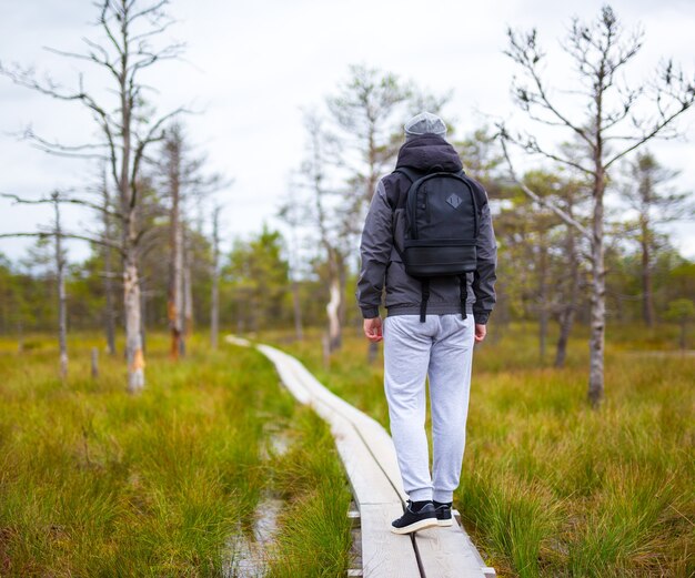 Hombre con mochila de senderismo en el bosque de otoño