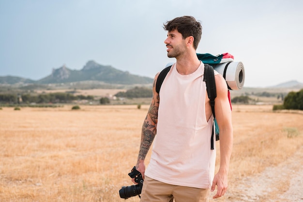 Hombre con mochila de senderismo y cámara al aire libre