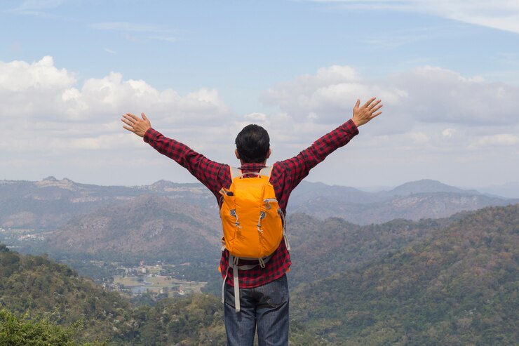 Hombre con la mochila en un top del paisaje hermoso del río del barranco del ower de la roca.