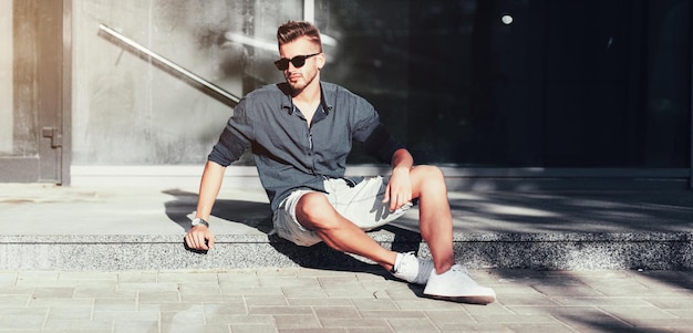 Foto hombre de moda con camisa y gafas de sol.