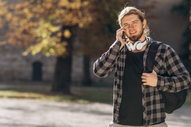 Hombre de moda en la ciudad con smartphone