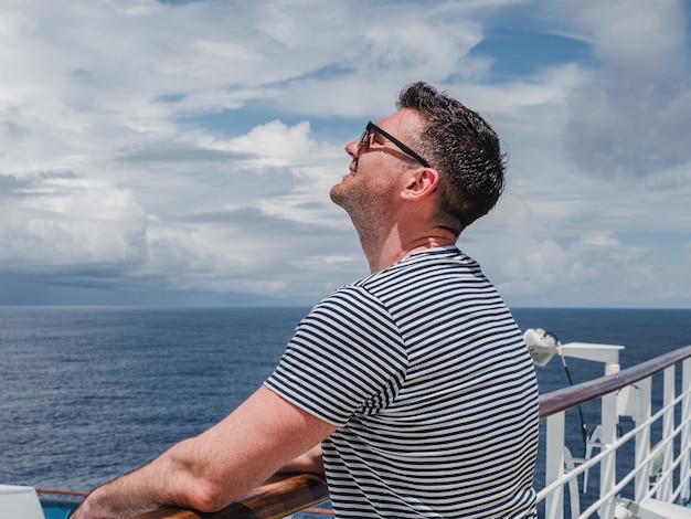 Hombre de moda en la cubierta vacía de un crucero