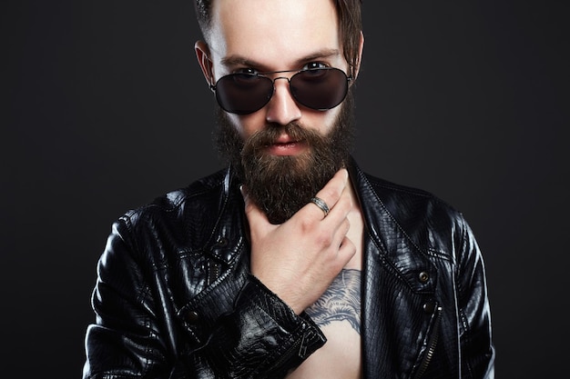 Hombre de moda con tatuaje y gafas de sol.