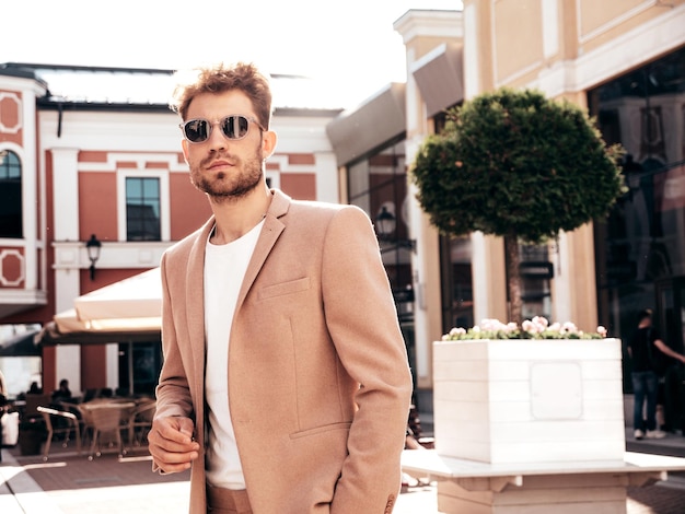 Hombre moderno y sexy vestido con un elegante traje beige en la calle
