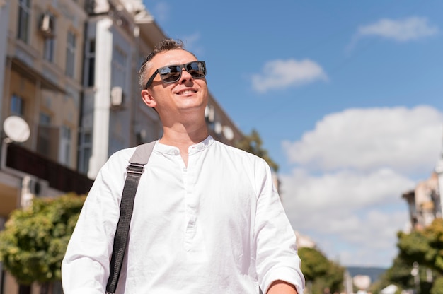 Foto hombre moderno sonriente caminando en la ciudad