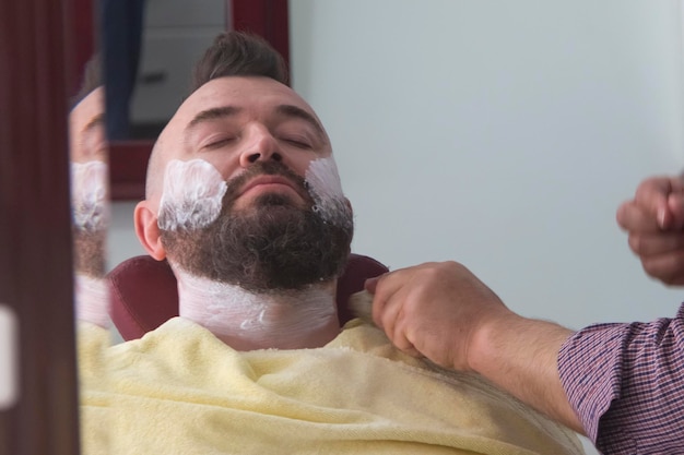 Un hombre con mohawk y barba en la barbería.