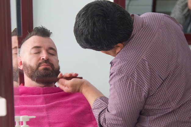 Un hombre con mohawk y barba en la barbería.