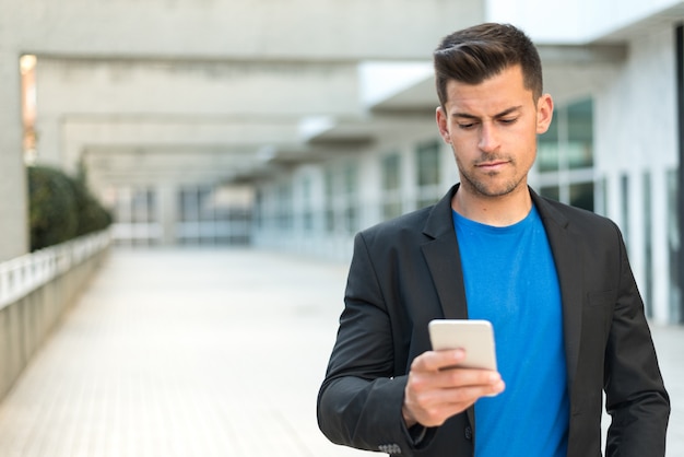 Foto hombre molesto enviando mensajes de texto en el teléfono móvil