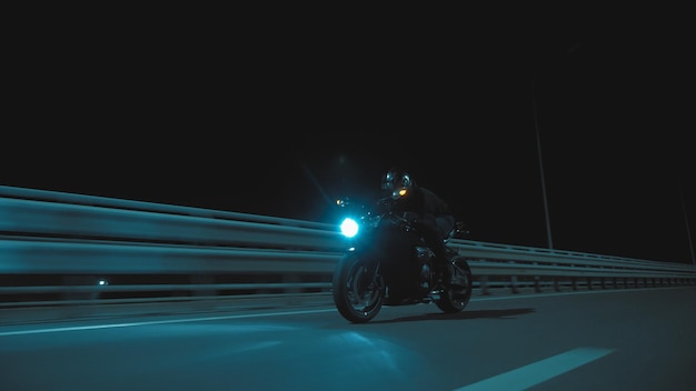 Un hombre monta una motocicleta deportiva en una pista nocturna.