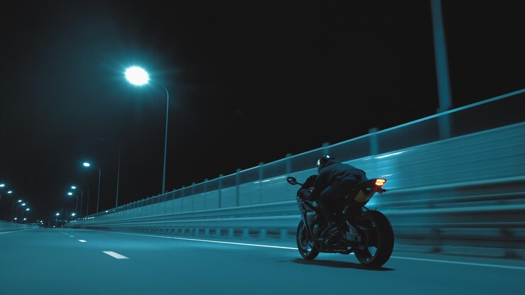Un hombre monta una motocicleta deportiva en una pista nocturna.