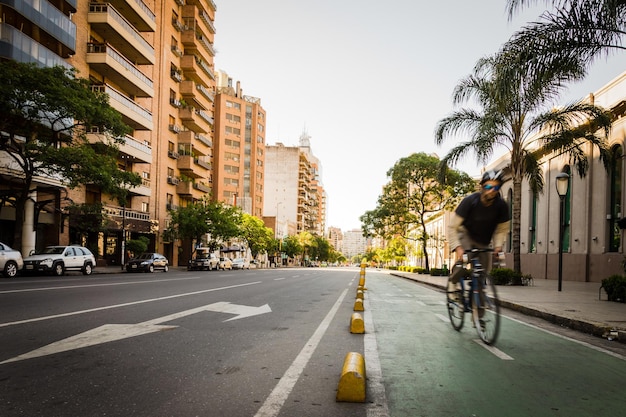Hombre montando en bicicleta en la calle de la ciudad contra un cielo despejado
