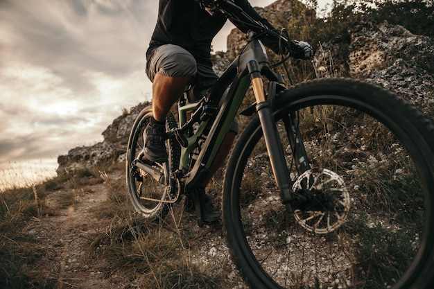 Hombre montando bicicleta de montaña en la noche nublada