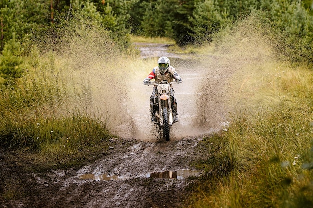 Hombre montando una motocicleta en el bosque