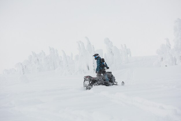 Hombre montando motos de nieve en los Alpes nevados