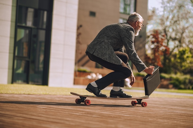 Un hombre montando una patineta y manteniendo el equilibrio.