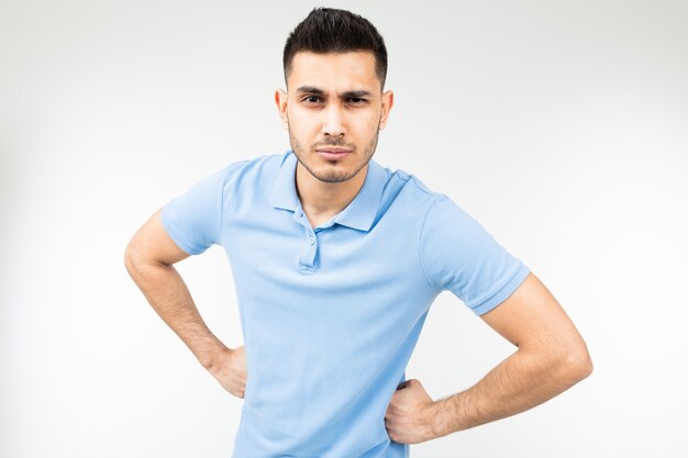 Hombre morena con una camiseta azul está enojado sobre un blanco aislado