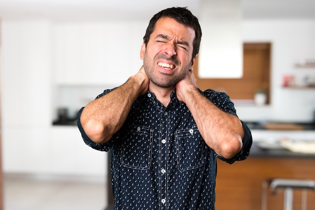 Hombre morena con dolor de cuello dentro de la casa