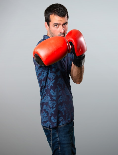 Foto hombre morena con guantes de boxeo sobre fondo gris