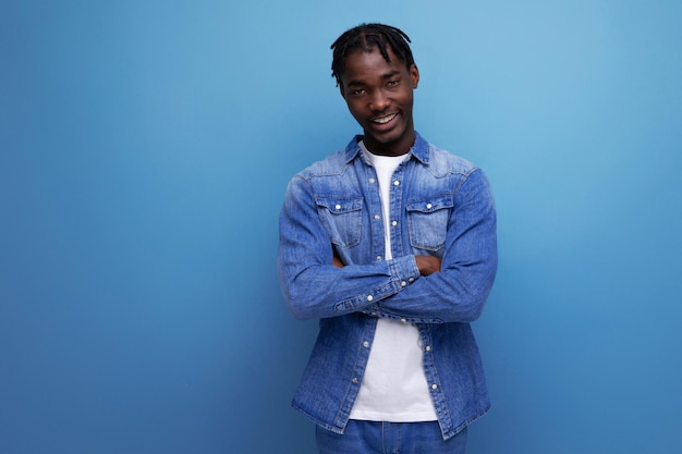 Hombre moreno bien arreglado con rastas en una chaqueta de mezclilla