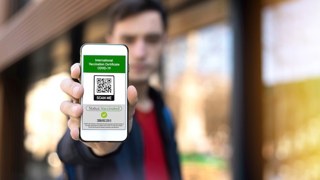 Hombre mostrando un código QR de certificado de vacunación internacional COVID-19 en smartphone