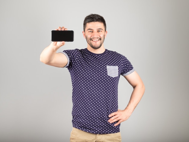 Hombre mostrando la pantalla en blanco de su teléfono