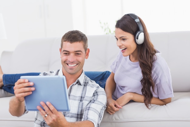 Hombre mostrando tableta digital a mujer sorprendida