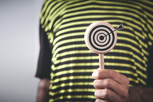 Hombre mostrando Target dart en ronda de madera