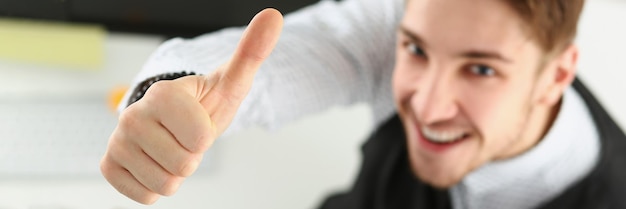 Hombre mostrando Thumbs up sign con mano oficinista alegre