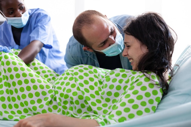 Foto hombre motivando a una mujer en la sala de parto en el hospital