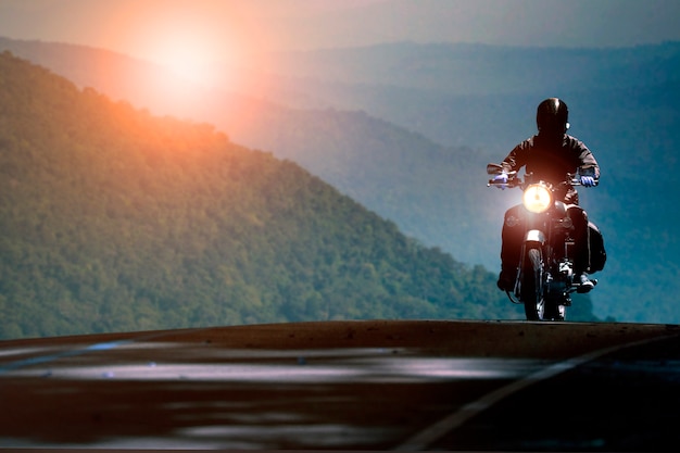 Hombre en motocicleta en la carretera de montaña