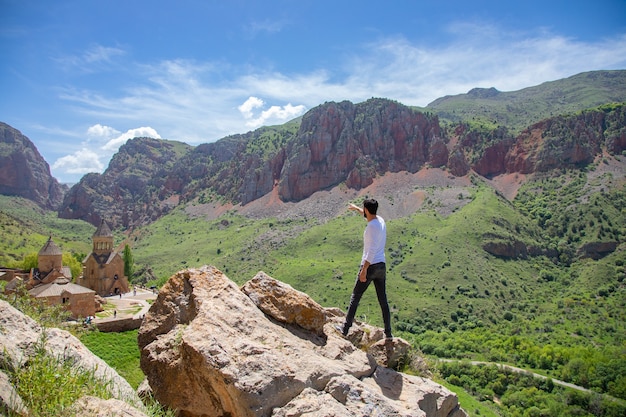 El hombre muestra rocas altas en la pared de la naturaleza