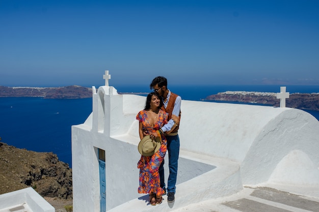 Un hombre y una mujer se abrazan en el contexto de Skaros Rock en la isla de Santorini. El pueblo de Imerovigli. Es un gitano étnico. Ella es israelí.