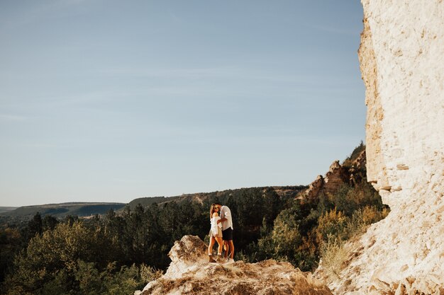 Un hombre y una mujer se abrazan en la montaña.