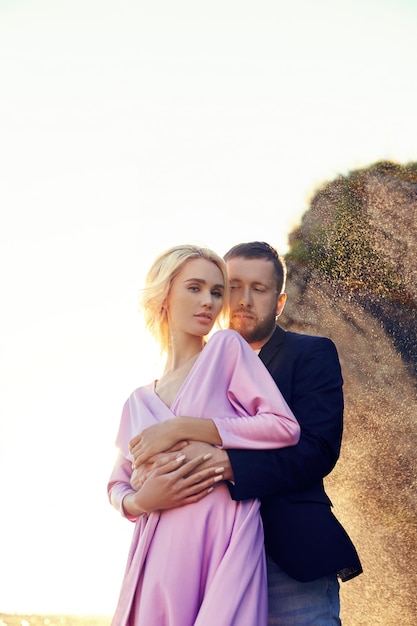 Hombre y una mujer abrazando en el verano al atardecer en ropa hermosa. Pareja