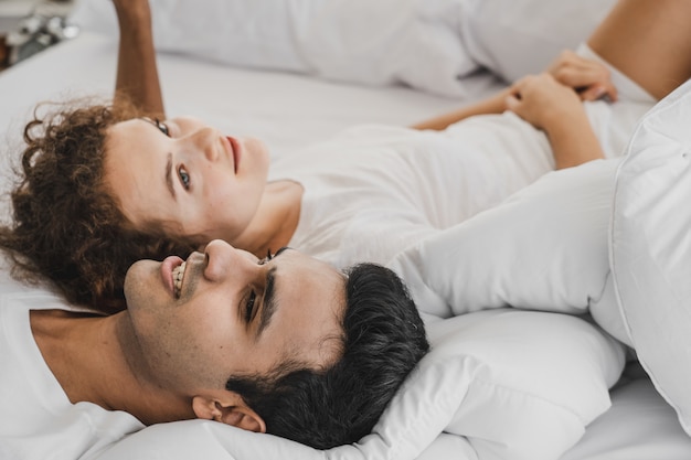 Foto un hombre y una mujer acostados en una cama.