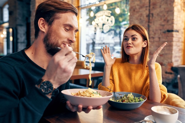 Foto hombre y mujer alegres sentados en un café comunicando emociones foto de alta calidad