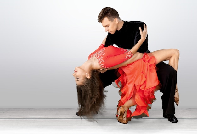 Hombre y mujer bailando salsa en la habitación.