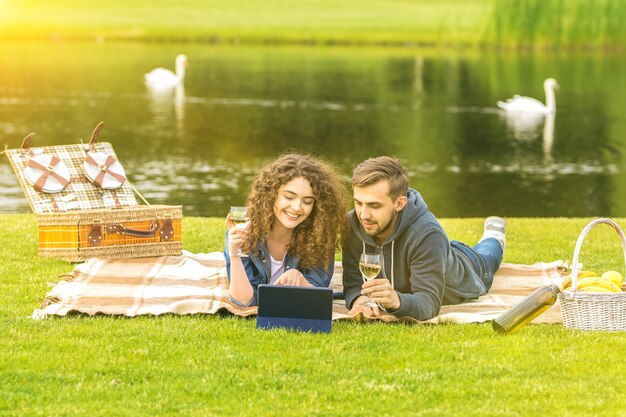 El hombre y la mujer beben un vino cerca del río.