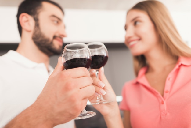 Un hombre y una mujer beben vino en la cocina.