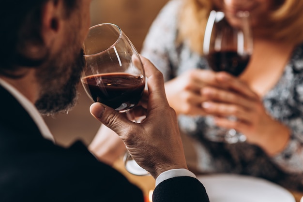 Hombre y mujer beben vino tinto de cerca