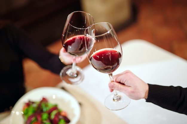 Foto hombre y mujer bebiendo vino tinto.