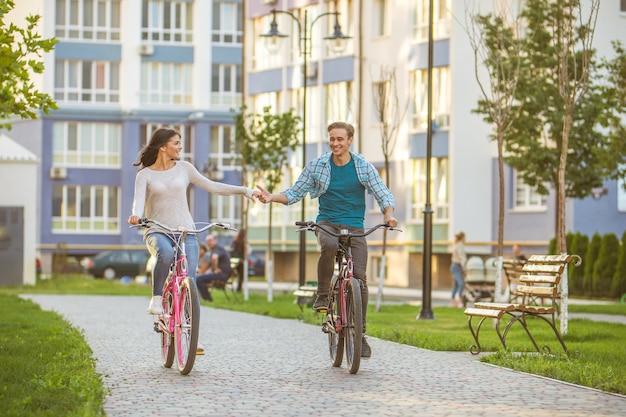 El hombre y la mujer en bicicleta en un parque residencial