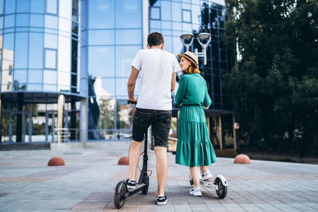 Hombre y mujer en blanco y negro scooters eléctricos. Vista trasera. Tecnologías de contenido.